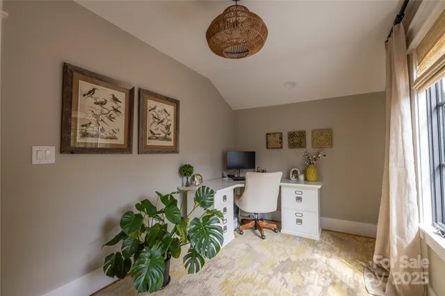 a view of a workspace with furniture and a window