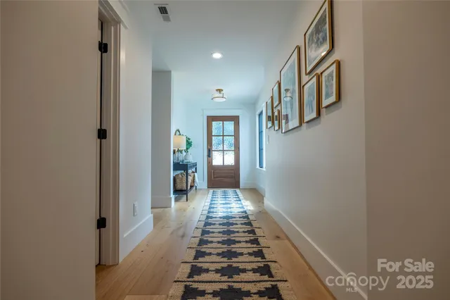a view of a hallway with wooden floor and staircase