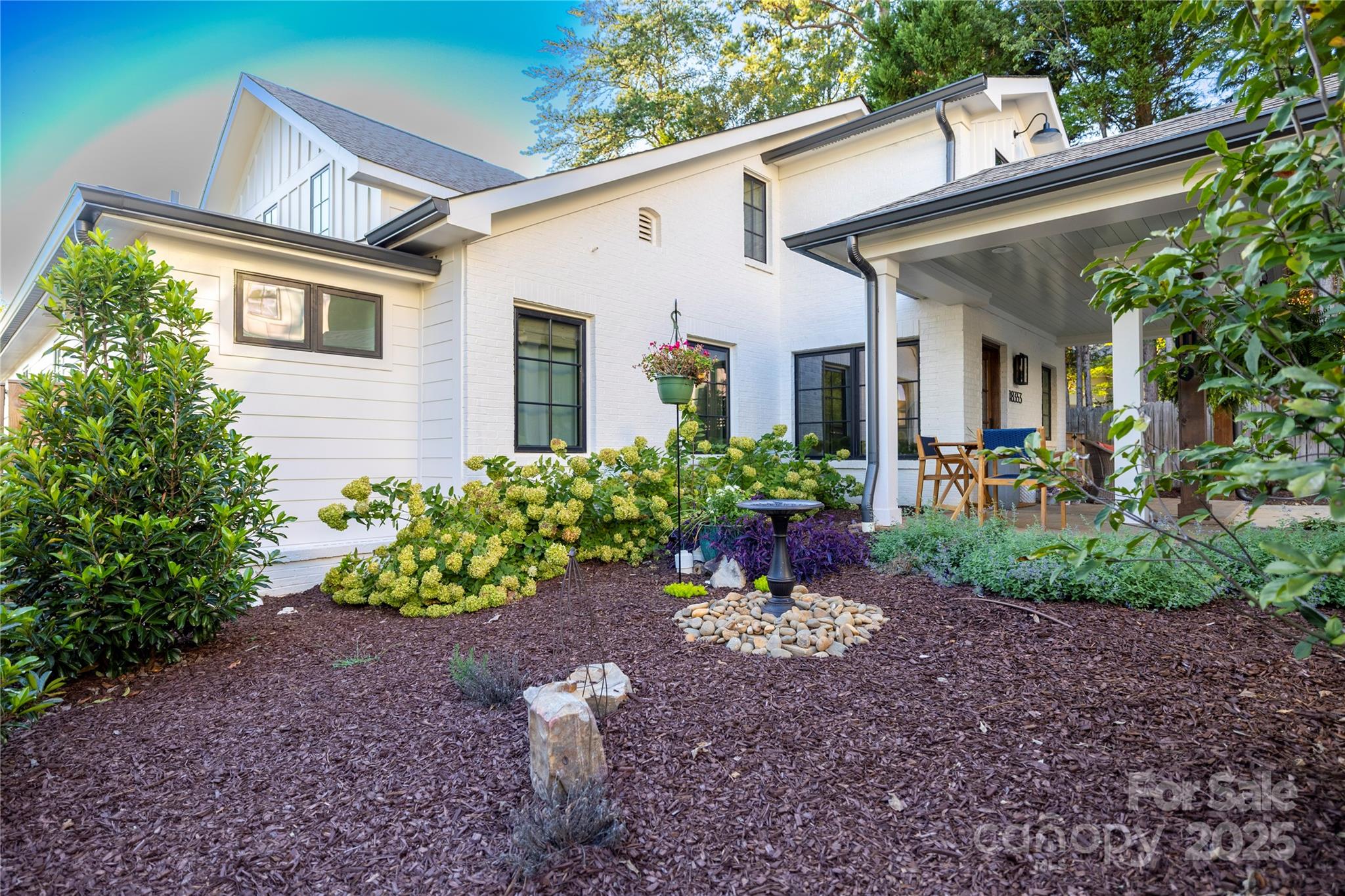 18353 John Connor Road Cornelius, NC 28031 - Photo 33 of 47 a view of a house with a yard and table and chairs under an umbrella