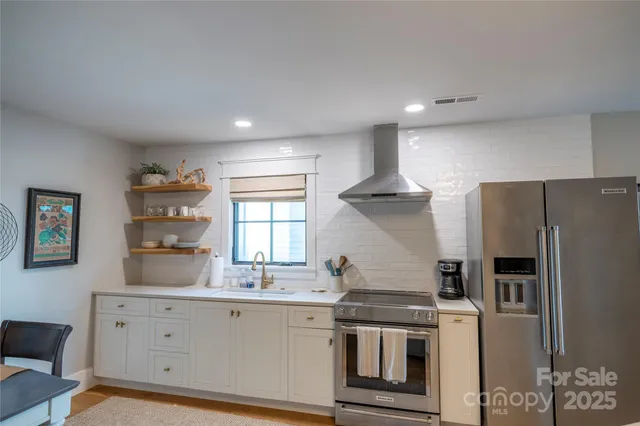 a kitchen with white cabinets and stainless steel appliances