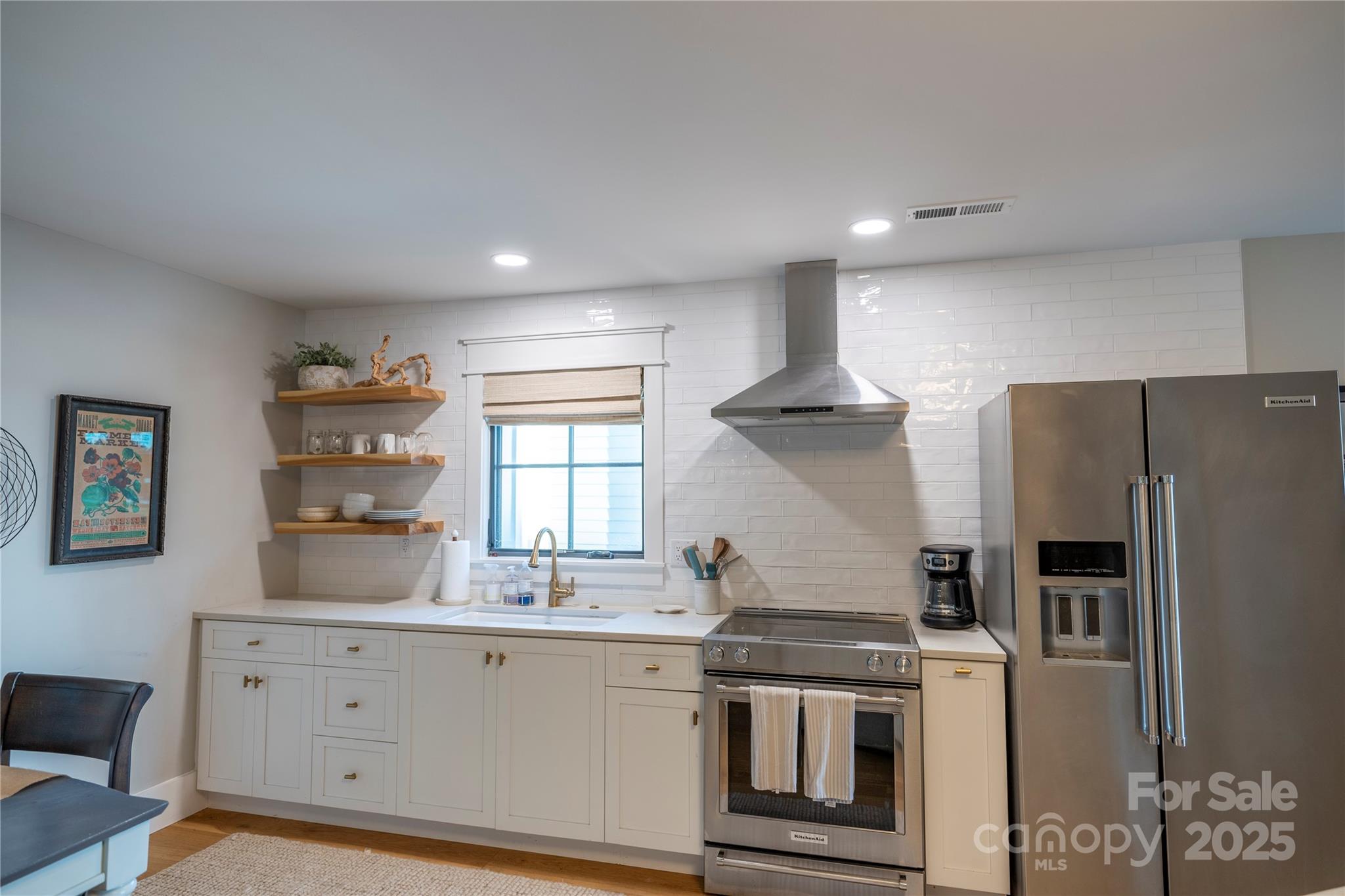 18353 John Connor Road Cornelius, NC 28031 - Photo 37 of 47 a kitchen with white cabinets and stainless steel appliances