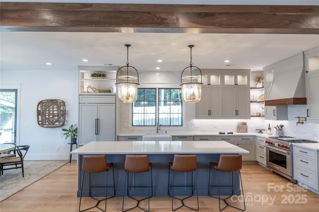 a kitchen with granite countertop a sink and white cabinets