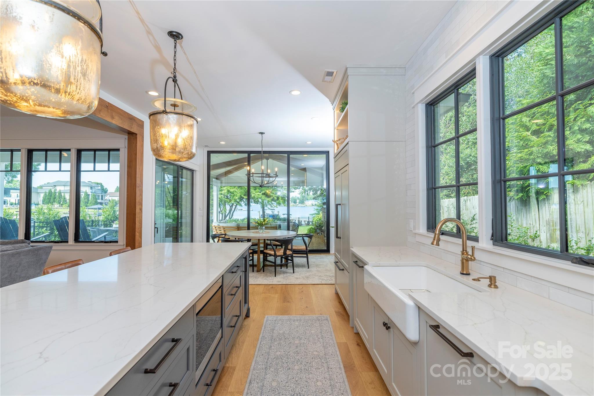 18353 John Connor Road Cornelius, NC 28031 - Photo 10 of 47 a large kitchen with kitchen island a large window cabinets a sink and stainless steel appliances