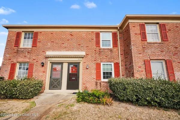 front view of a brick house with a large window