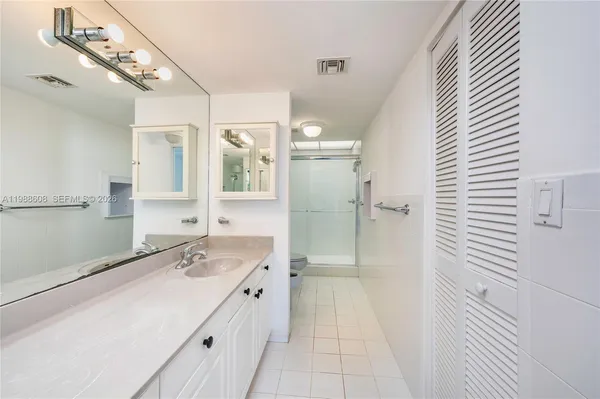 a bathroom with a sink a mirror and shower