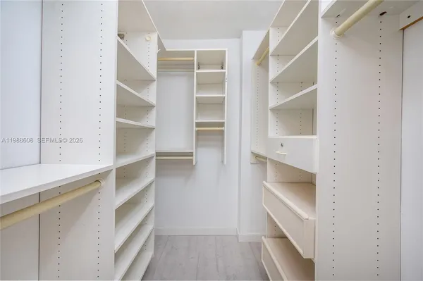 a view of walk in closet with empty racks