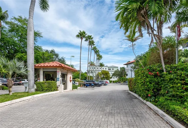 a view of a house with a yard and palm trees