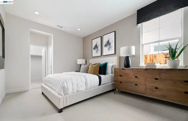 a bedroom with a bed and a potted plant