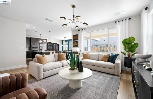 a living room with patio furniture and a chandelier