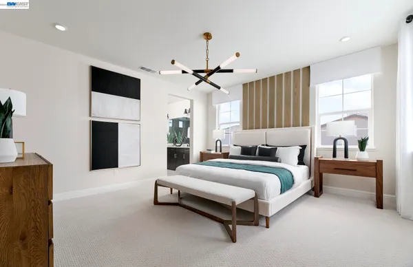 a spacious bedroom with a bed and a chandelier