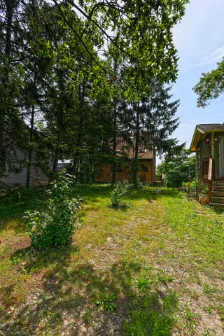 an aerial view of residential houses with outdoor space and trees
