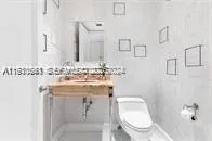 a bathroom with a sink a toilet and a mirror