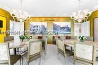 a very nice looking dining room with a large window with dining table and chairs