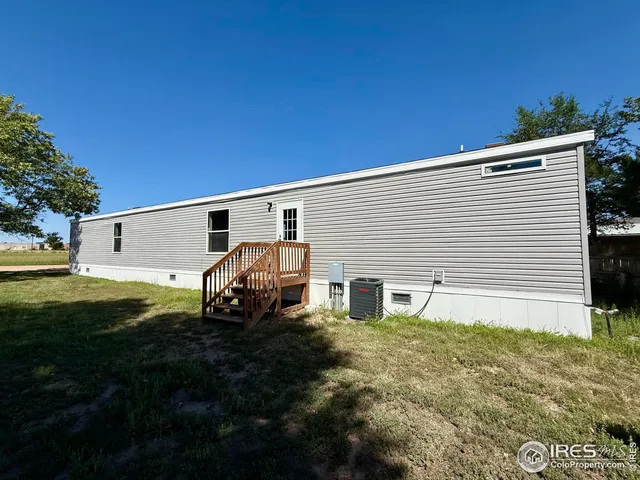 a backyard of a house with barbeque oven and a garden