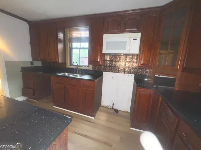 a kitchen with granite countertop sink and cabinets