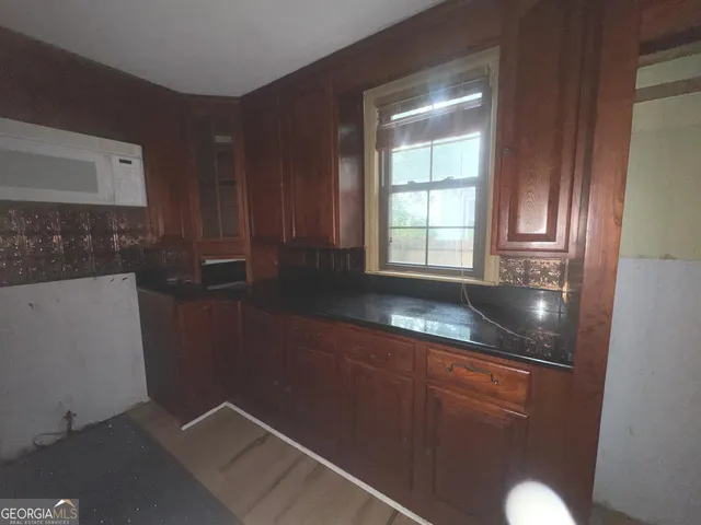 a kitchen with granite countertop a sink and a stove top oven