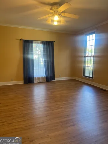 a view of a room with wooden floor and windows