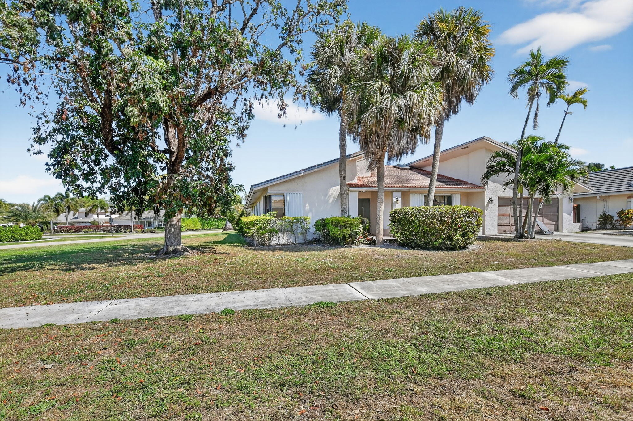 22220 Morning Glory Terrace Boca Raton, FL 33433 - Photo 5 of 69 a front view of a house with a yard and palm trees