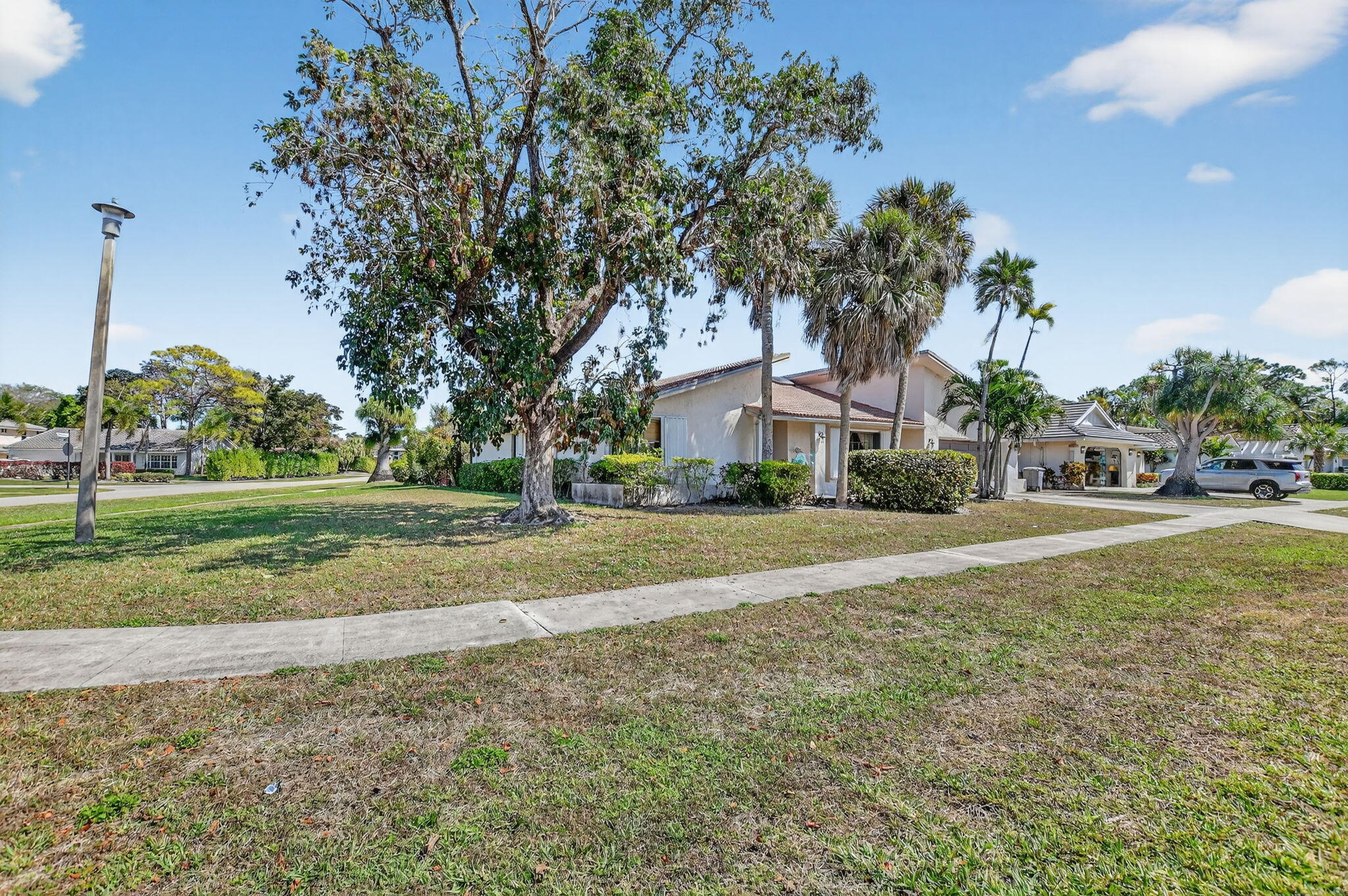 22220 Morning Glory Terrace Boca Raton, FL 33433 - Photo 6 of 69 a view of a house with a yard and palm trees