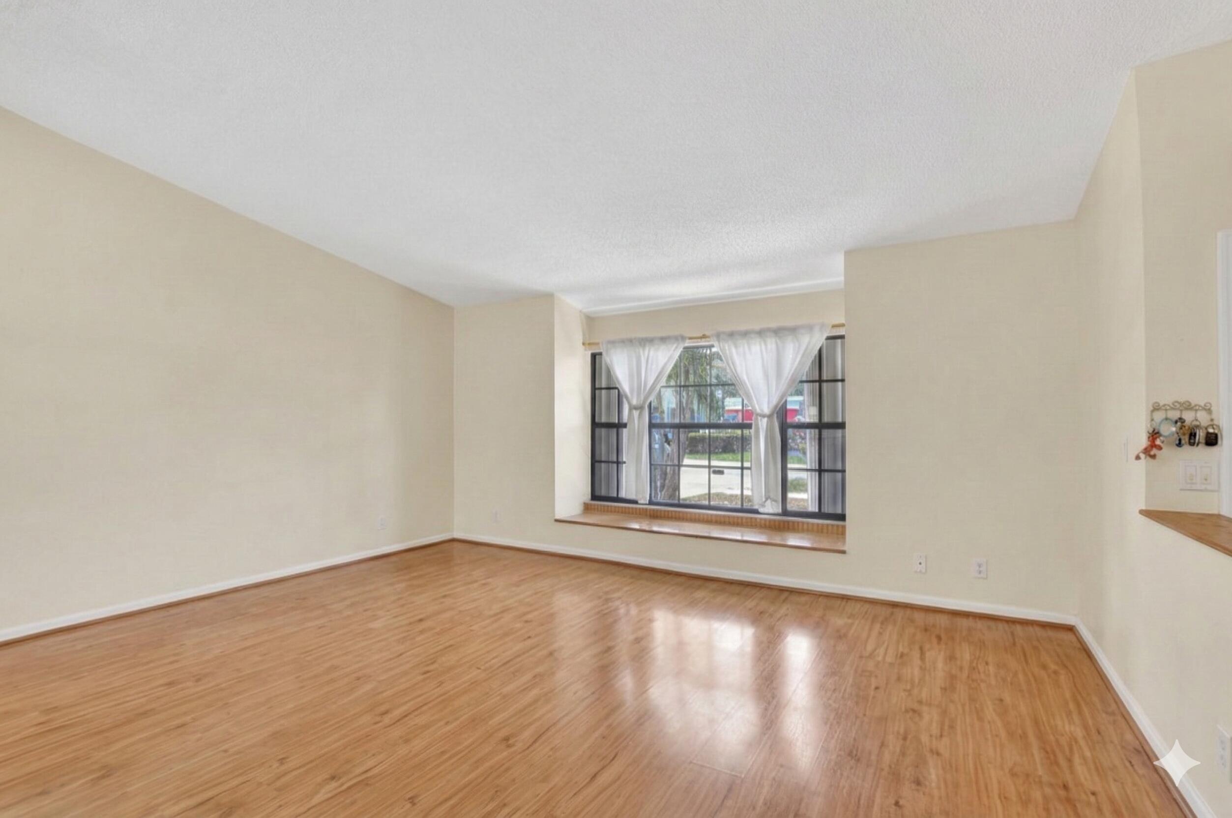 22220 Morning Glory Terrace Boca Raton, FL 33433 - Photo 61 of 69 a view of an empty room with wooden floor and a window