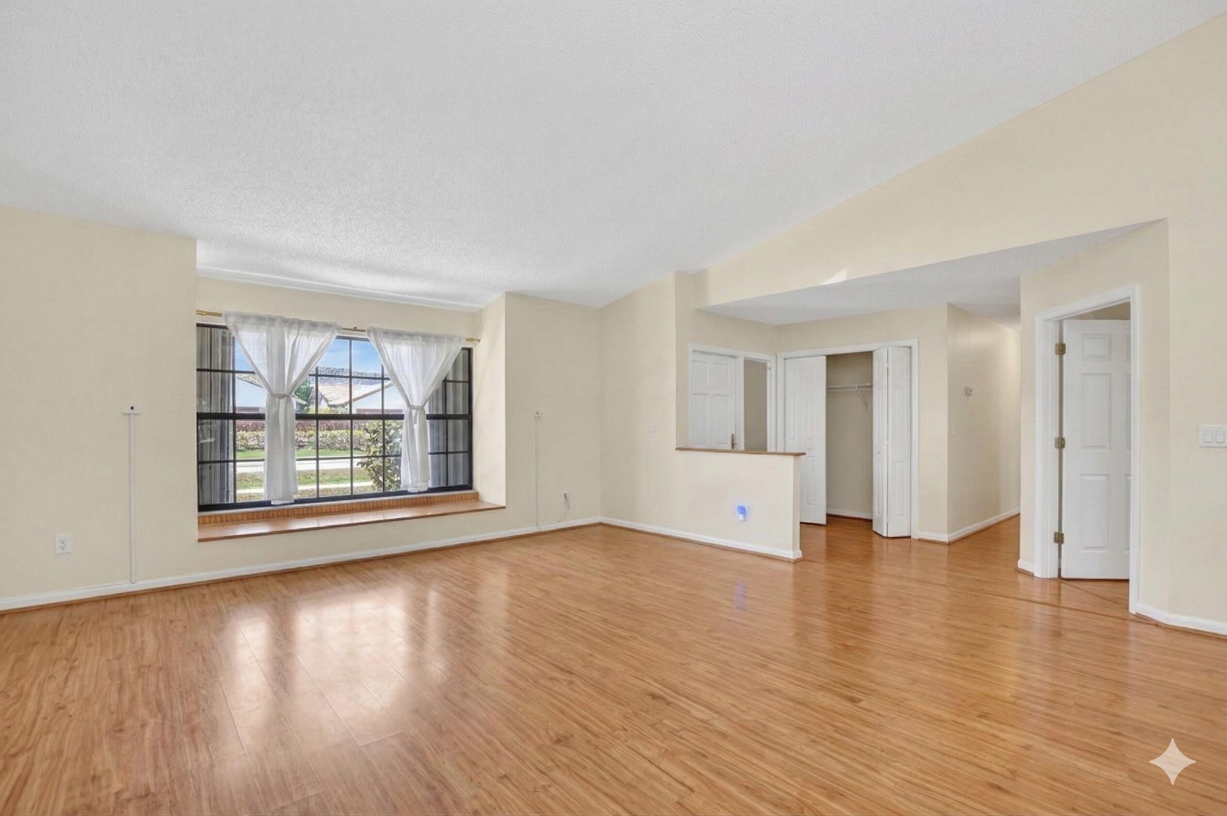 22220 Morning Glory Terrace Boca Raton, FL 33433 - Photo 62 of 69 a view of an empty room with wooden floor and a window