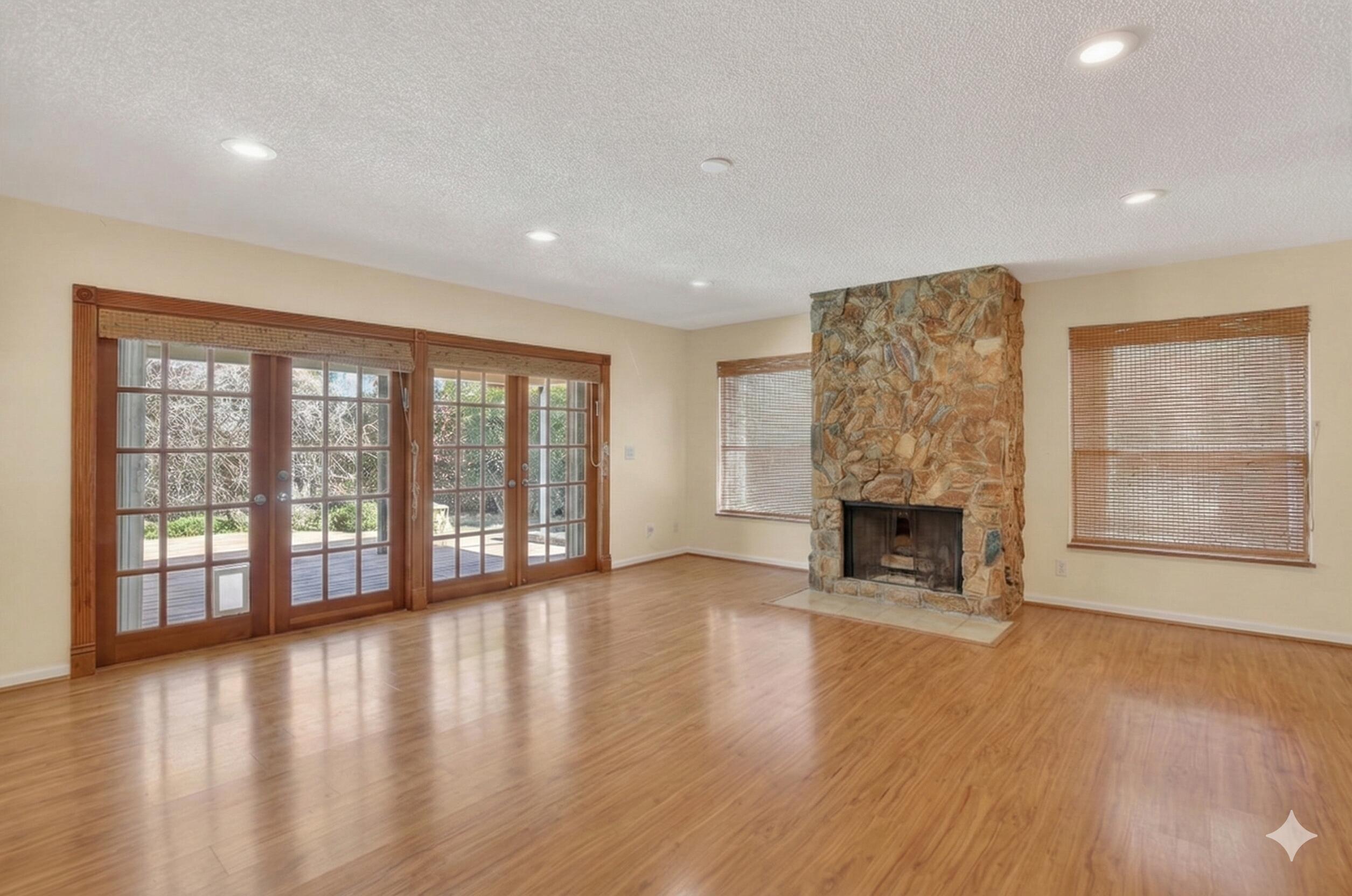 22220 Morning Glory Terrace Boca Raton, FL 33433 - Photo 10 of 69 a view of an empty room with wooden floor and a fireplace