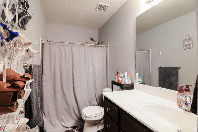 1077 South 1850th Street West Springville, UT 84663 - Photo 15 of 22 Full bath with vanity, a shower with shower curtain, and a textured ceiling