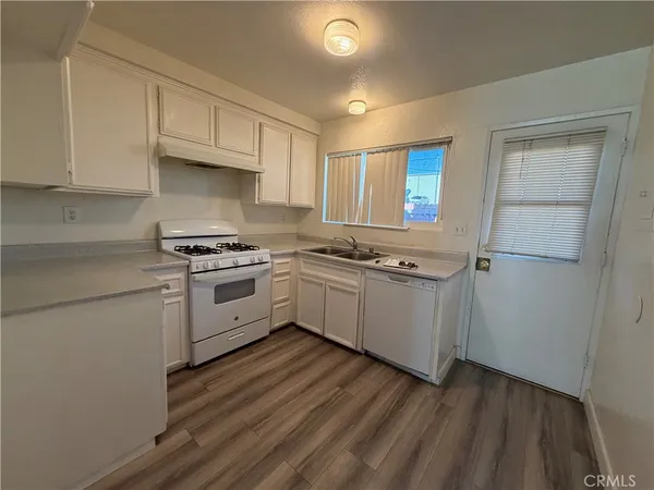 a kitchen with white cabinets and white appliances