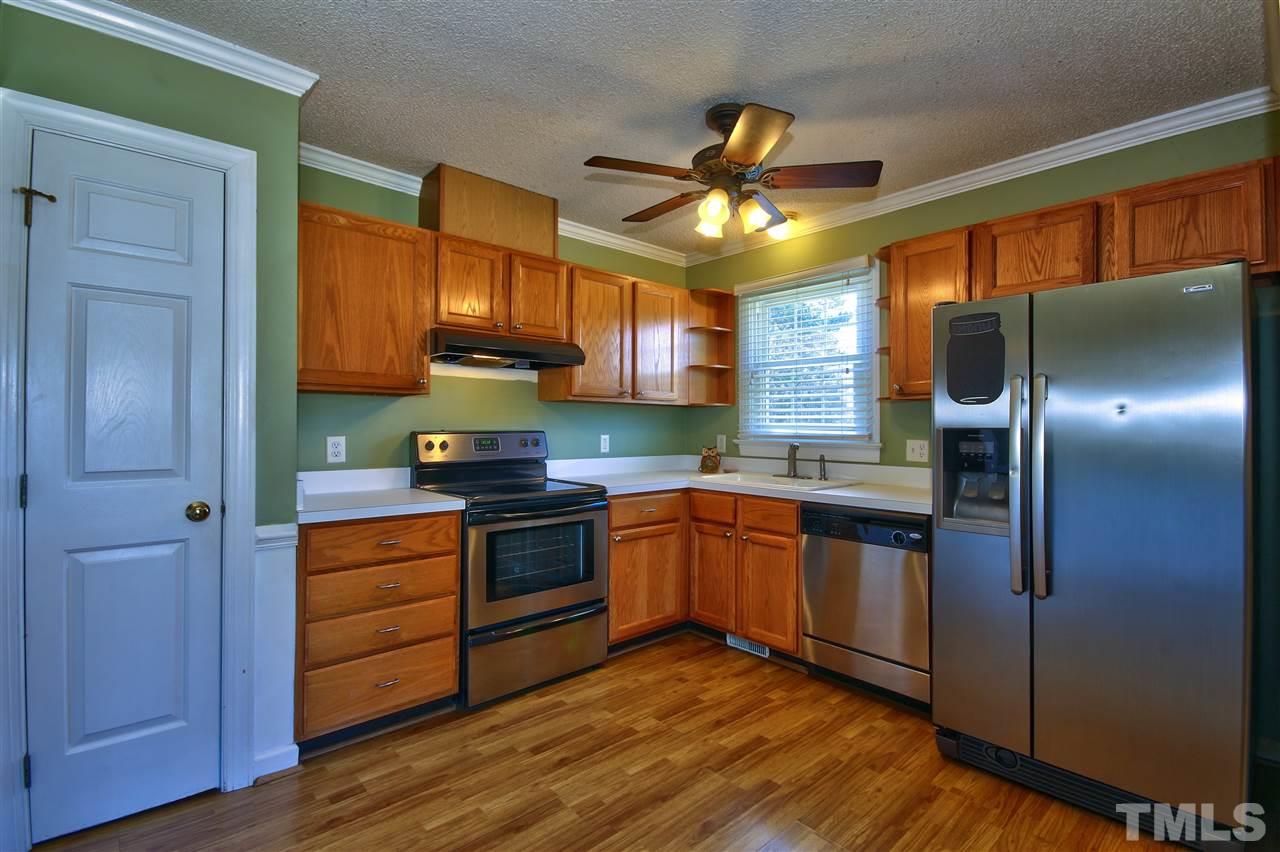 2937 Old Crews Road Raleigh, NC 27616 - Photo 9 of 19 a kitchen with stainless steel appliances granite countertop wooden cabinets a refrigerator a sink a stove and a wooden floors