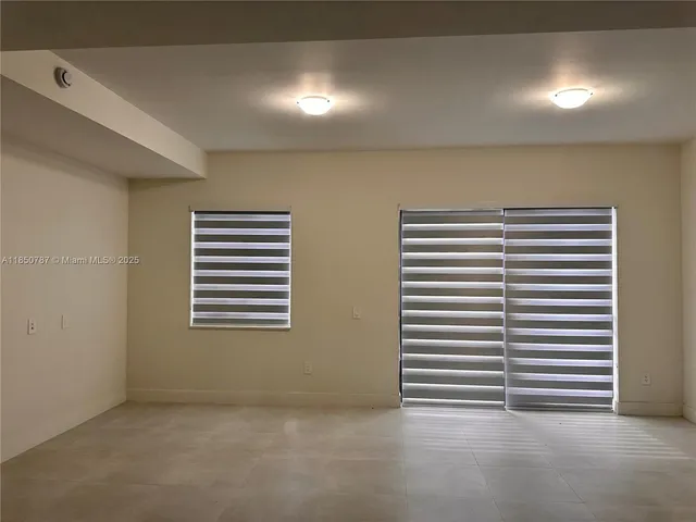a view of a room with a window and a ceiling fan