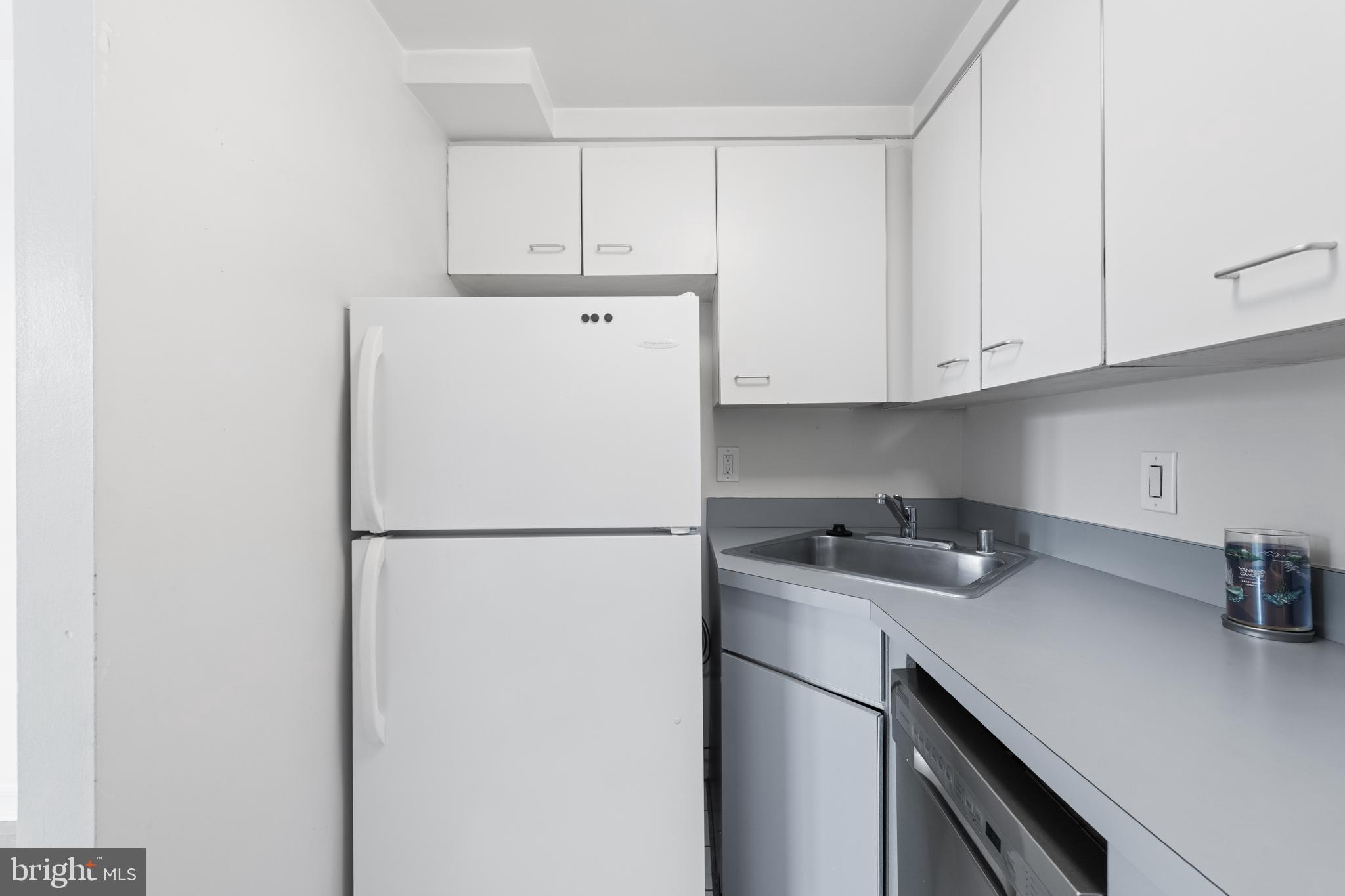 2611 Adams Mill Road Northwest, Unit 208 Washington, DC 20009 - Photo 15 of 22 a white refrigerator freezer sitting in a kitchen