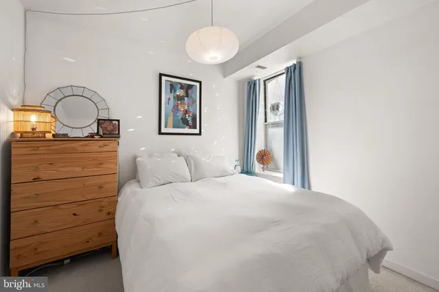 a bedroom with a bed and a painting on the wall