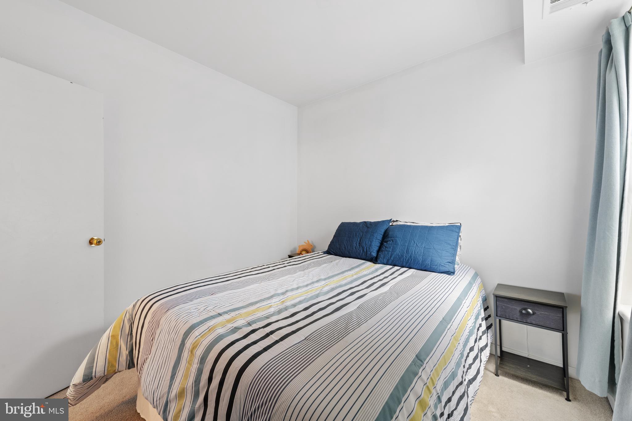 2611 Adams Mill Road Northwest, Unit 208 Washington, DC 20009 - Photo 17 of 22 a bedroom with a bed and a chair