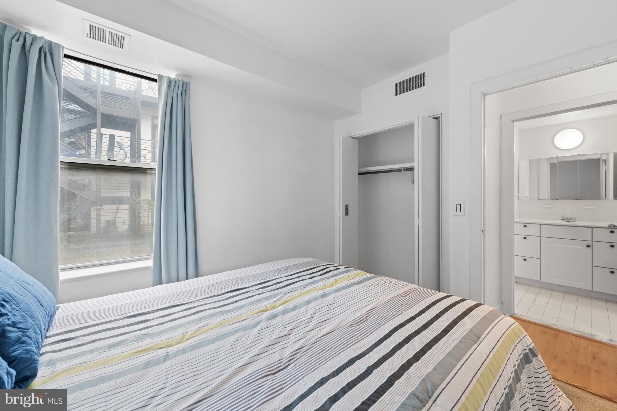 2611 Adams Mill Road Northwest, Unit 208 Washington, DC 20009 - Photo 18 of 22 a bedroom with a bed and a large mirror