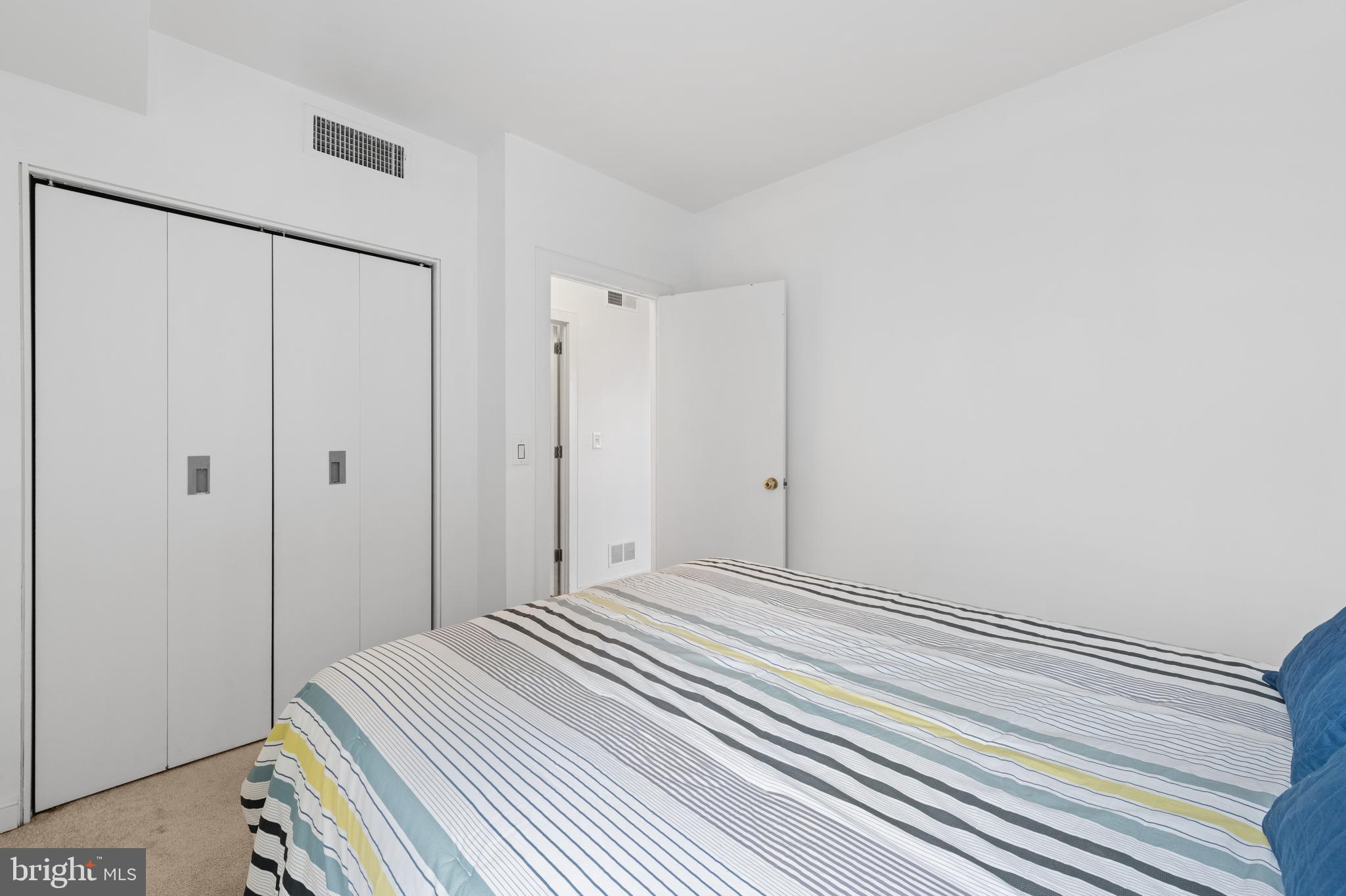 2611 Adams Mill Road Northwest, Unit 208 Washington, DC 20009 - Photo 19 of 22 a bedroom with a bed and a shower curtain