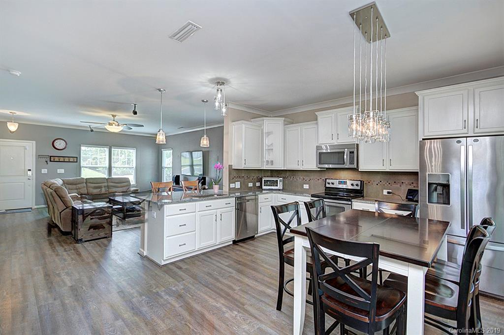8008 Bryson Road Indian Land, SC 29707 - Photo 12 of 22 a kitchen with stainless steel appliances a dining table chairs stove refrigerator and microwave
