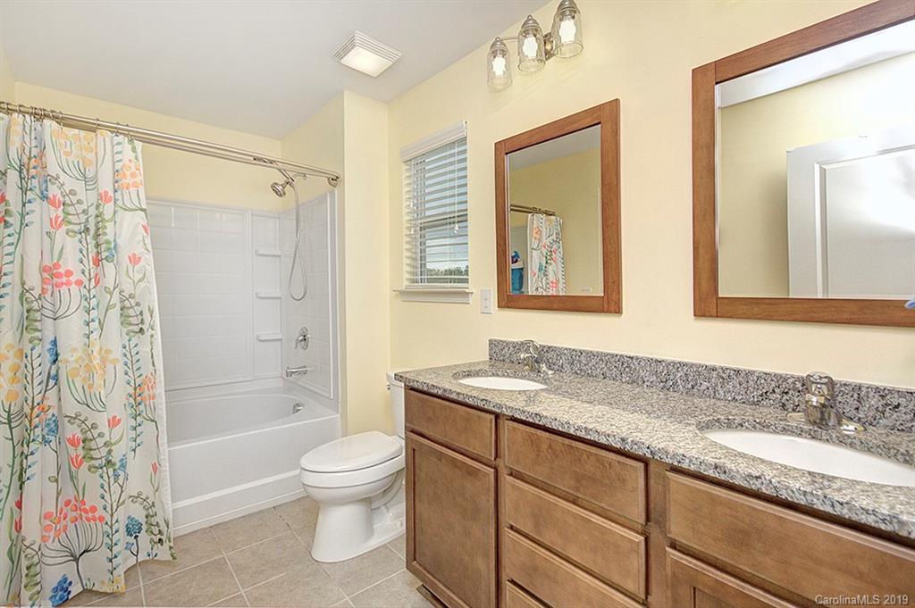 8008 Bryson Road Indian Land, SC 29707 - Photo 21 of 22 a bathroom with a granite countertop sink a toilet and shower