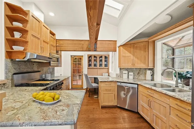 a kitchen with stainless steel appliances granite countertop sink stove and cabinets