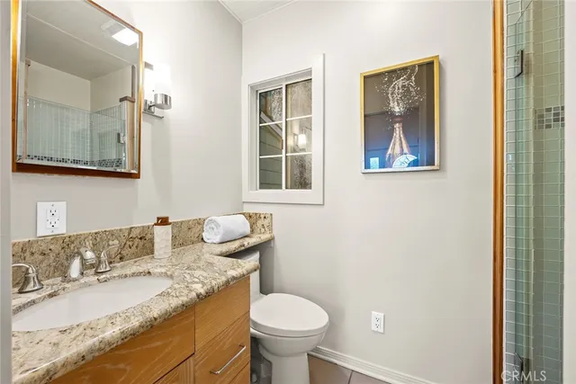 a bathroom with a granite countertop toilet sink and mirror
