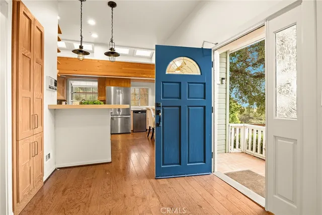 a view of a kitchen with a refrigerator and wooden floor