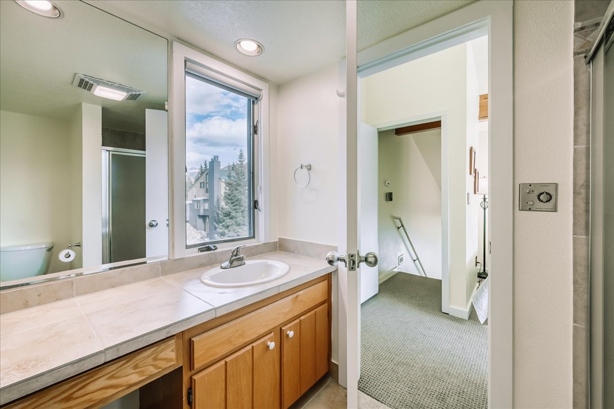 22280 Highway 6, Unit 1716 Keystone, CO 80435 - Photo 22 of 27 a bathroom with a sink a mirror and a shower
