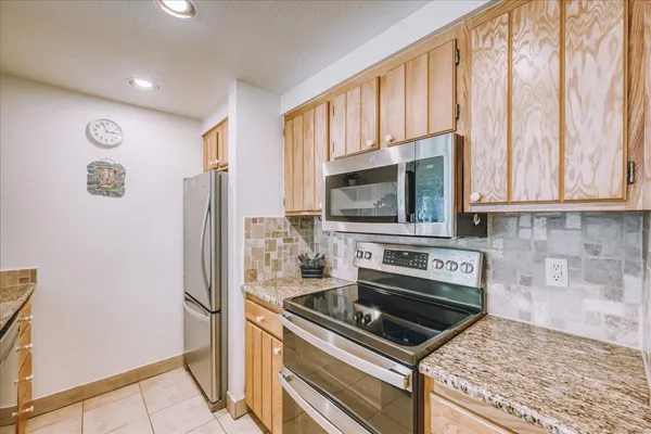 a kitchen with stainless steel appliances granite countertop a refrigerator stove and microwave