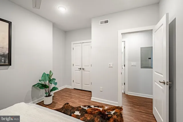 a bedroom with a bed and wooden floor