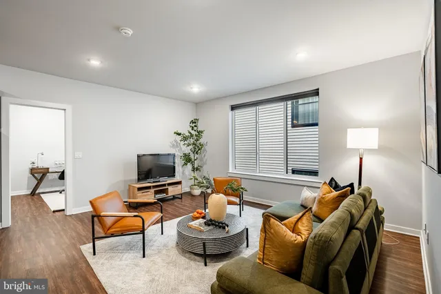 a living room with furniture a window and a lamp