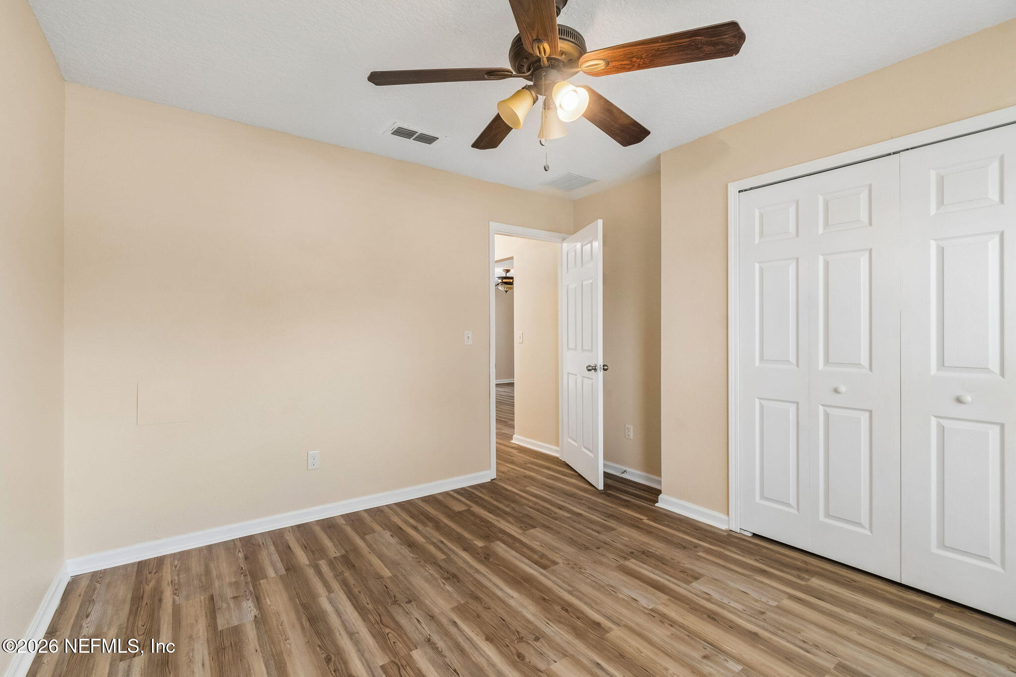 73 South Twin Maple Road St. Augustine, FL 32084 - Photo 31 of 59 an empty room with wooden floor chandelier fan and closet area with wooden floor