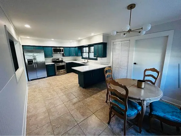 a living room with furniture a rug and kitchen view