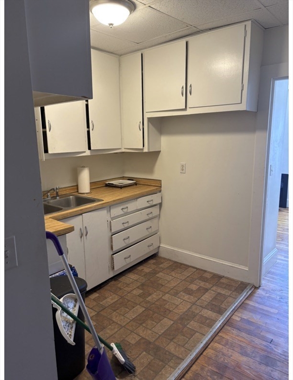913 Rodman Street Fall River, MA 02721 - Photo 12 of 13 a kitchen with a sink cabinets and wooden floor