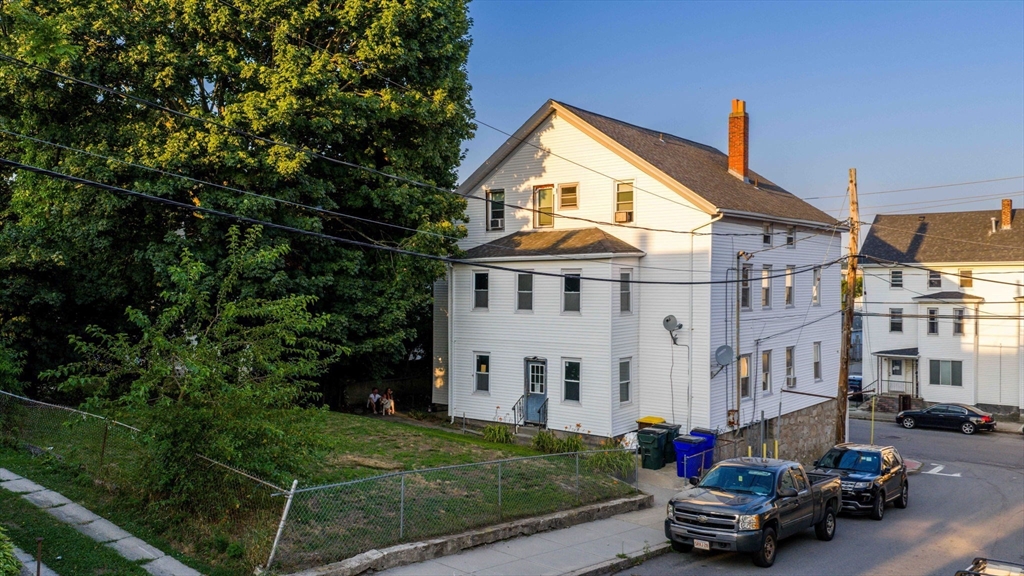 913 Rodman Street Fall River, MA 02721 - Photo 4 of 13 a view of a white house with a small yard and sitting area