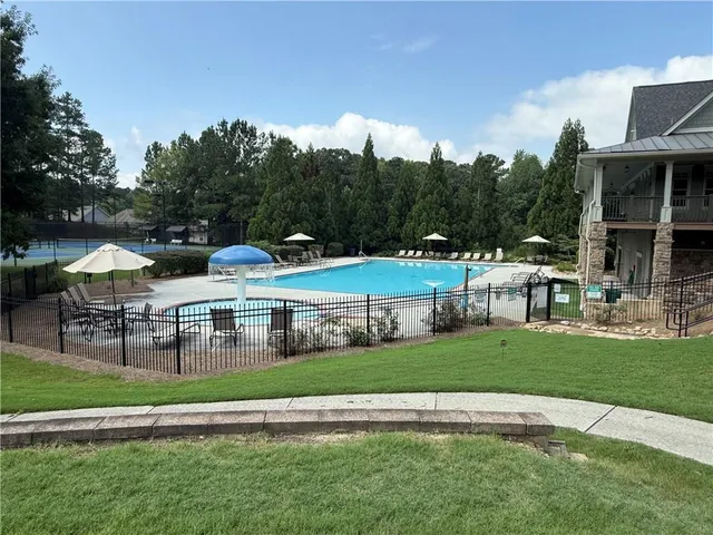 a view of a big yard with table and chairs under an umbrella