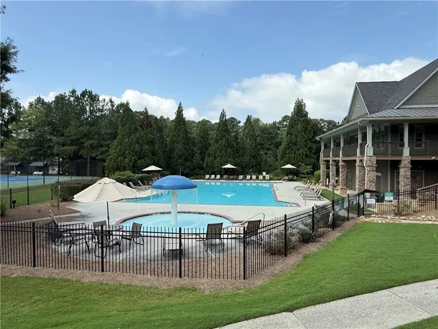 a view of a house with backyard and sitting area